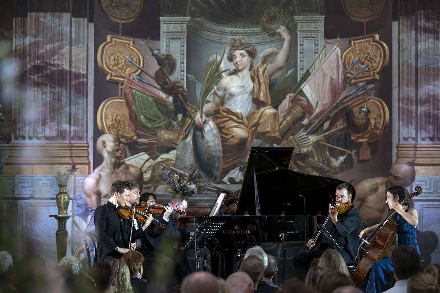 Chamber concert in a hall with baroque paintings