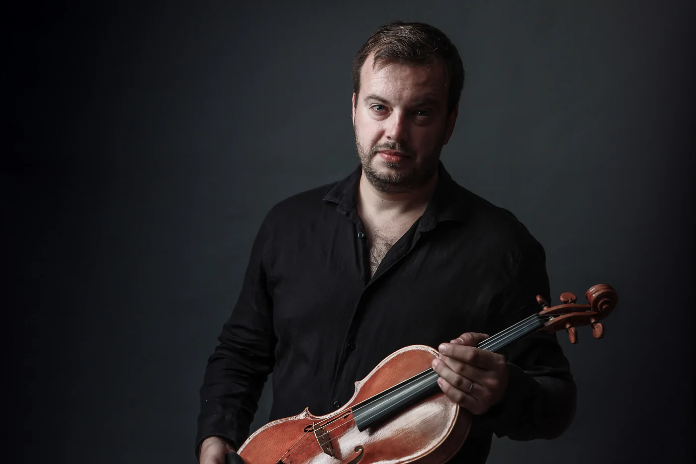 Jiří Kabát with his viola against a dark grey background