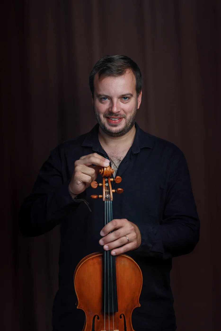 Jiří Kabát holding his viola by the scroll