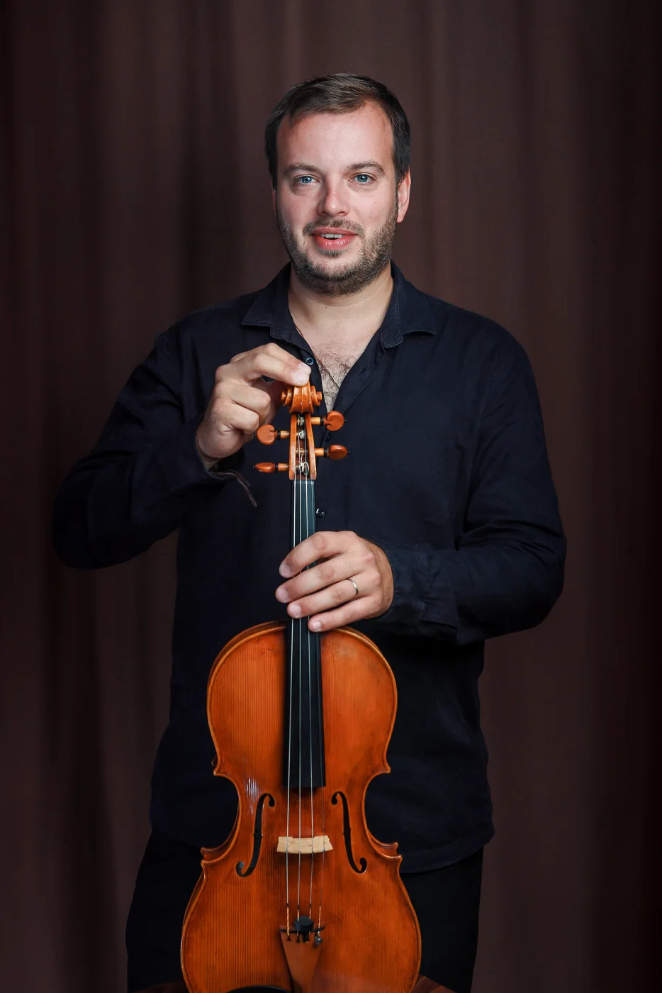 Jiří Kabát with his viola standing upright in front of him