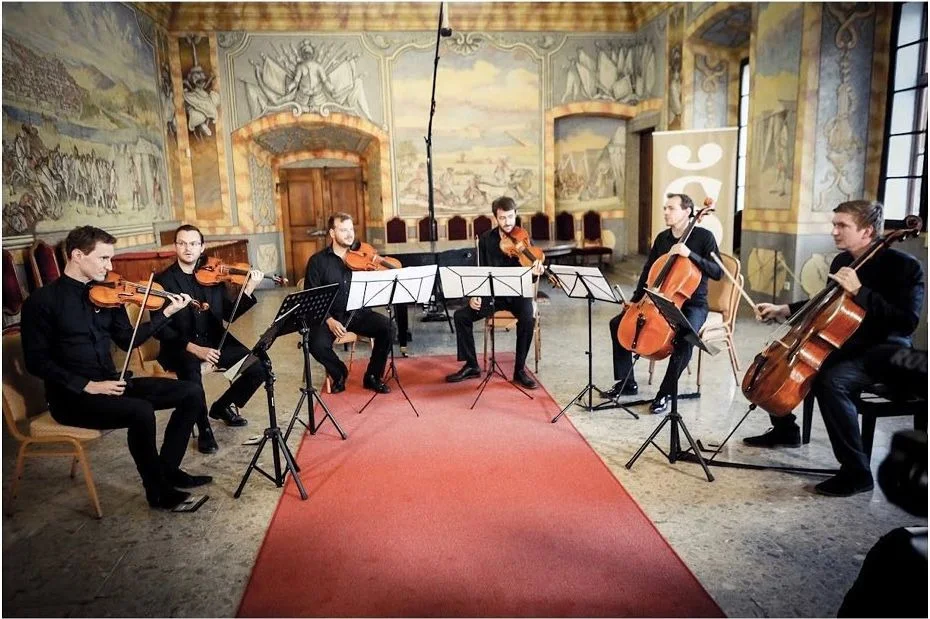Chamber ensemble in a hall with wall paintings